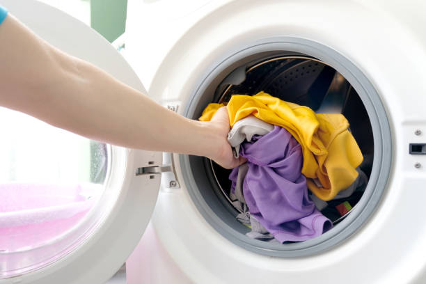 istock man's hand Pick up clothes Washing machine.Clean and Healthy Concepts 1145140621