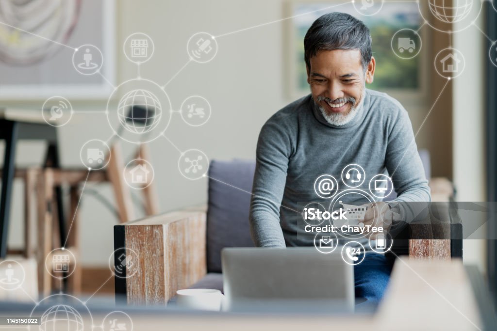 Asian or Hispanic man using Laptop and credit card payment shopping online with icon customer network connection on screen and connecting with omni channel system. Older man satisfied with CRM system Customer Stock Photo