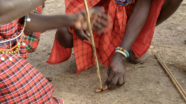 istock two maasai men use a hand drill to start a fire at a manyatta in kenya 1145152148