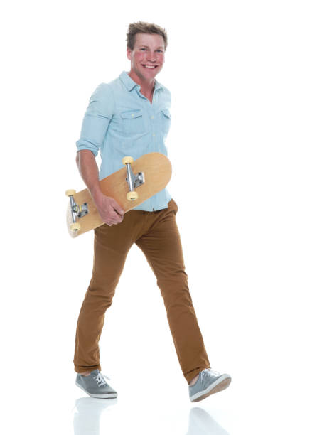istock Casual well dressed man walking with a skateboard 1145152463