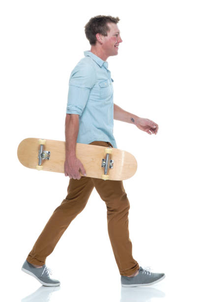 istock Casual well dressed man walking with a skateboard 1145152501