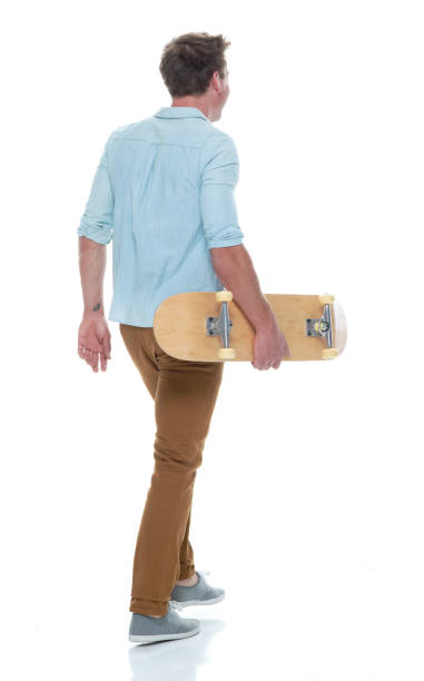 istock Casual well dressed man walking with a skateboard 1145152503