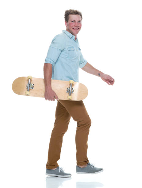 istock Casual well dressed man walking with a skateboard 1145152514