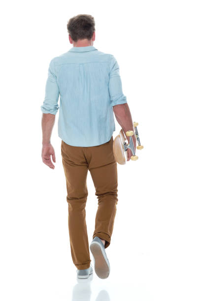 istock Casual well dressed man walking with a skateboard 1145152538