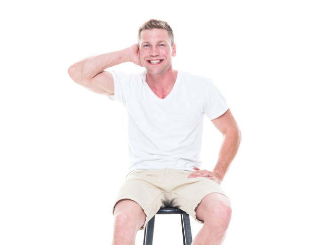 istock Handsome man in shirt and shorts is sitting on stool 1145153503