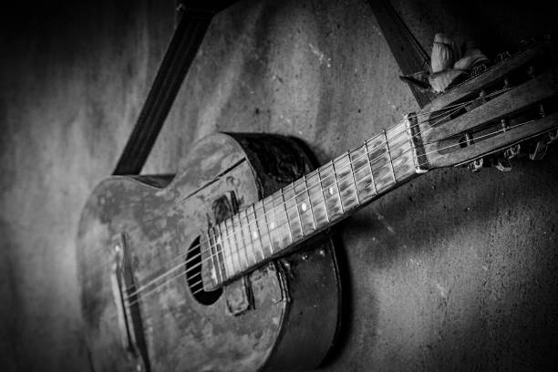 istock old guitar on concrete wall background with blurred front and back background with bokeh effect 1145153640