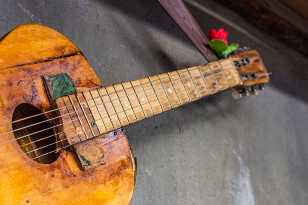 istock old guitar on concrete wall background with blurred front and back background with bokeh effect 1145153648
