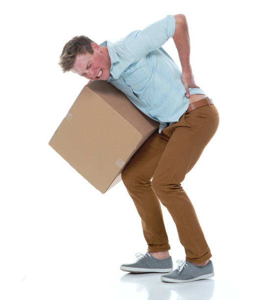 istock Good looking man holding a brown box and has back pain 1145153782