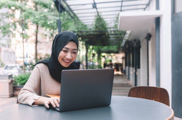 istock Asian Malaysian Malay working using laptop at cafe smiling 1145154513
