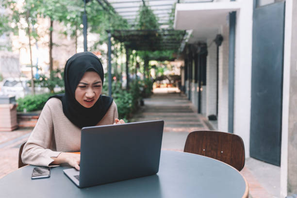 istock Asian Malaysian Malay working using laptop at cafe frustrating 1145154601