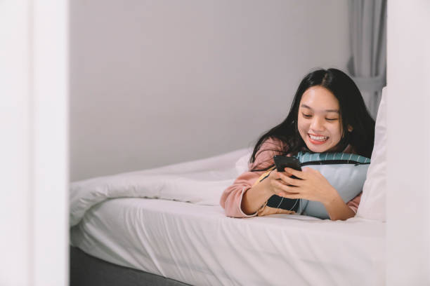 istock Asian chinese female at Home using phone alone smiling 1145155000