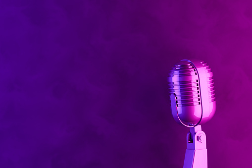 Old style microphone with retro background, color gradient. Vintage concept. Neon lights.