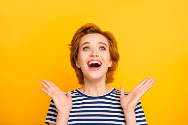 istock Close up photo beautiful she her lady look up empty space unexpected free abroad journey hands arms raised wearing casual striped white blue t-shirt outfit clothes isolated yellow bright background 1145167607