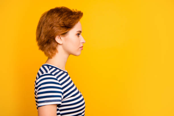 istock Close up side profile photo beautiful amazing she her lady look empty space not smiling wondered listen wear casual striped white blue t-shirt outfit clothes isolated yellow bright background 1145167719