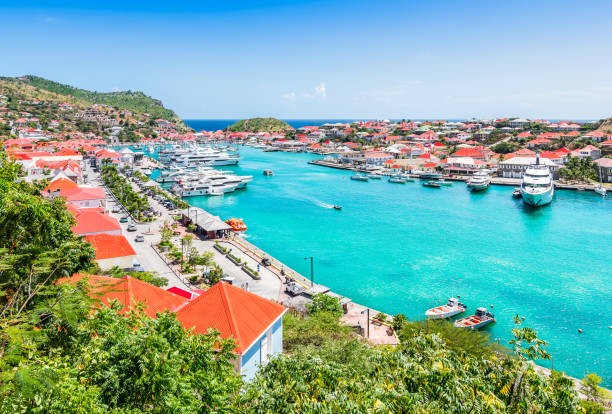 Gustavia harbor, St Barts, Caribbean Bright and colorful harbor image of Saint Barthelemy. Aerial view with blue sky and turquoise colored water in the marina.Buildings with red roofs along the waterfront. french overseas territory photos stock pictures, royalty-free photos & images