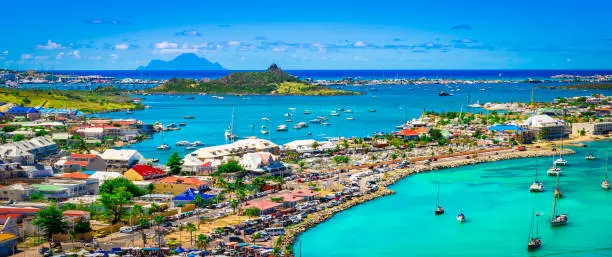 Aerial view of town and ocean of Saint Martin, French side of the Caribbean Island. Bright and colorful panorama landscape with blue sky and turquoise blue sea. Viewpoint from Fort Louis at the marina.