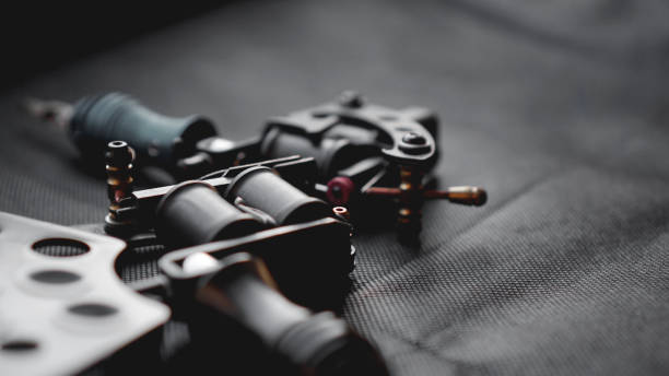 istock Tattoo machine and tattoo supplies on dark background 1145168914
