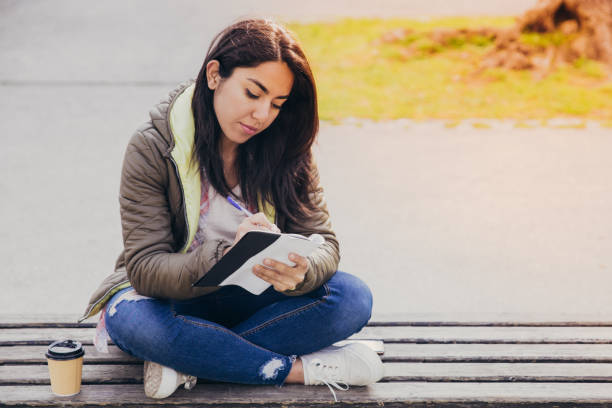 istock Busy student girl writing down ideas in diary 1145170819