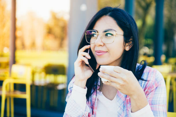 istock Content woman talking on phone and drinking coffee in cafe 1145170851