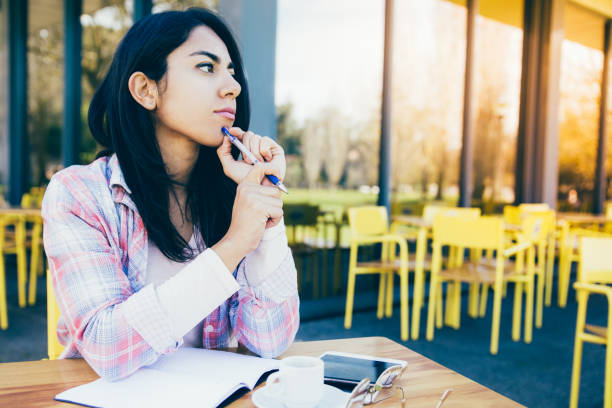 istock Thoughtful woman making notes in outdoor cafe 1145170882