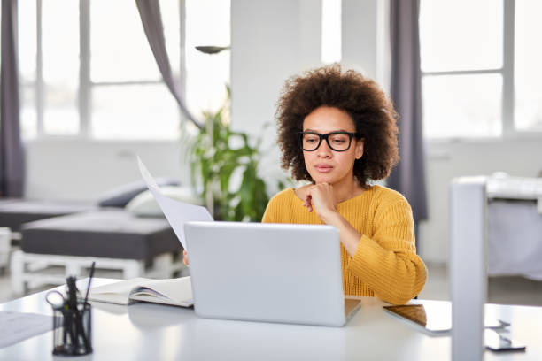 istock Businesswoman finishing paperwork while sitting in office. 1145174931