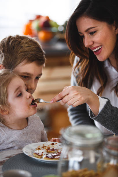 istock Mother feeding her little daughter breakfast 1145175037