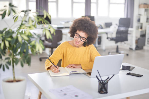 istock Businesswoman taking notes while sitting in office. 1145175885