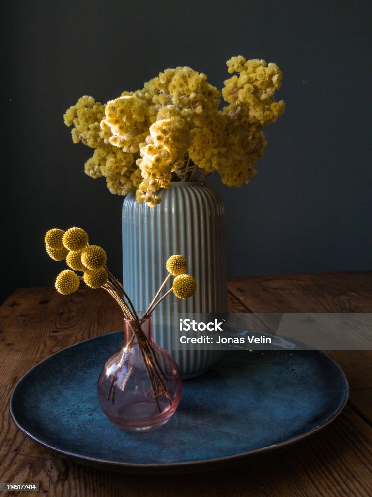 fortfarande liv av vas med gula blommor på en blå platta - Royaltyfri Vas Bildbanksbilder