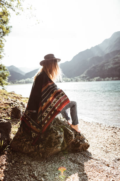istock folk woman with a poncho sitting on a stone 1145178540