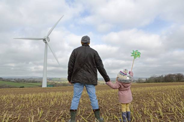 istock Father and daughter walk to wind turbine 1145178690