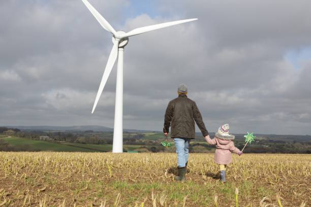 istock Father and daughter walk to wind turbine 1145178748