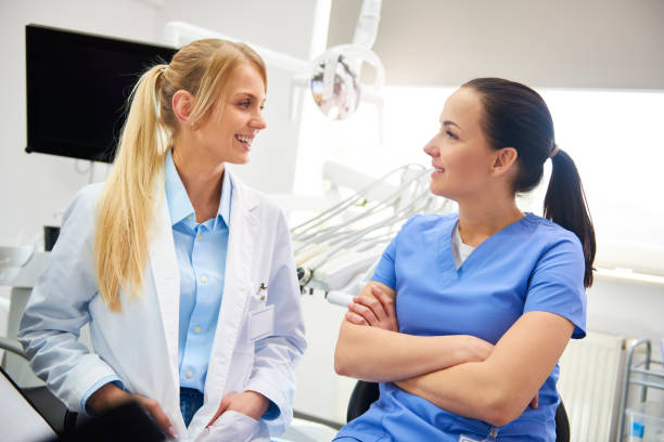 istock Two smiling, female dentist sitting face to face 1145181284