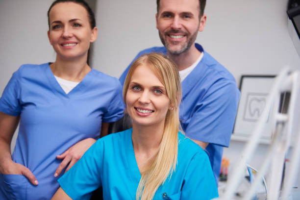 istock Team of smiling and satisfied dentists in dentist's office 1145181402