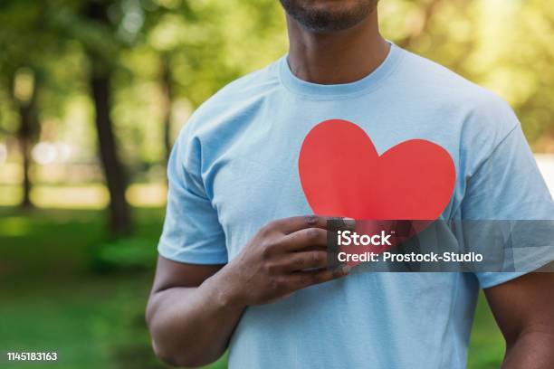 Black Man Holding Red Heart On His Chest Stock Photo - Download Image Now - Heart Shape, Healthy Lifestyle, Volunteer