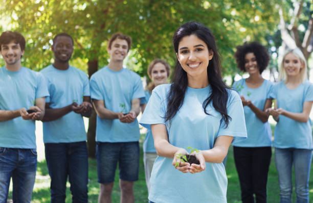 grupa wolontariuszy z drzewami do uprawy - planting tree human hand women zdjęcia i obrazy z banku zdjęć