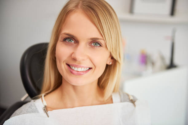 портрет приятной и улыбающейся женщины в стоматологической клинике - smiling dentist office dentists chair women стоковые фото и изображения