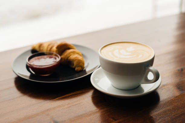 istock Cup of cappuccino and croissant with jam 1145189375