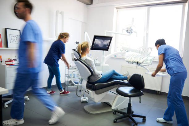 blurred view of dentists and woman in dentist's clinic - dentist office dentists chair dental equipment white imagens e fotografias de stock