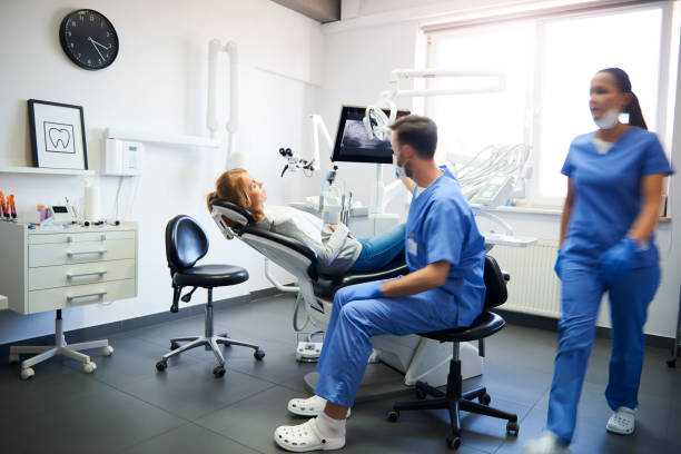 blurred view of busy dentists at work - dentist office dentists chair dental equipment white imagens e fotografias de stock