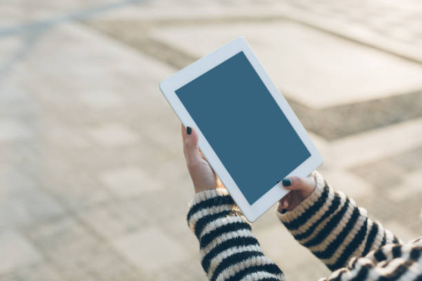 istock Young woman using iPad outdoors 1145190545