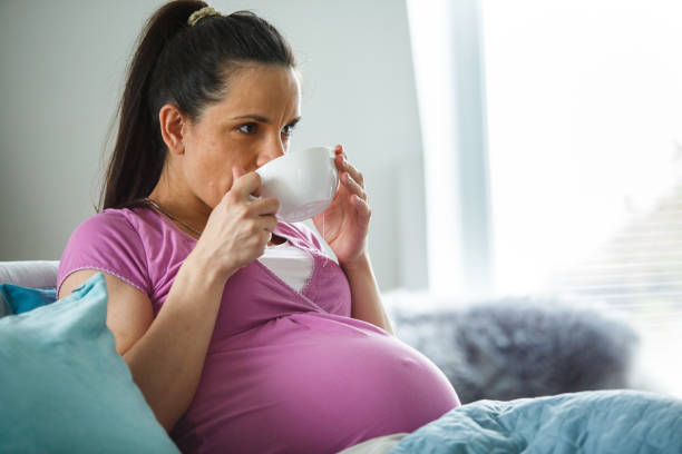 istock Pregnant woman drinks tea in the bed while relaxing 1145190969