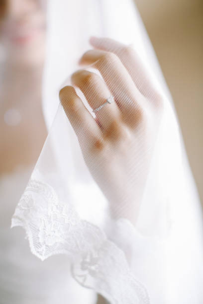istock bride in wedding dress holding veil 1145192298