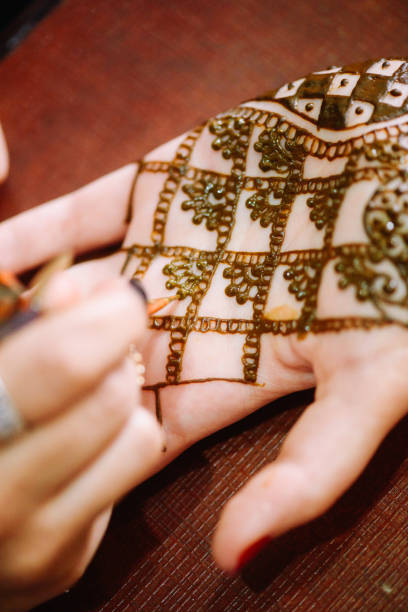 istock Artist drawing henna tattoo on hand 1145192396