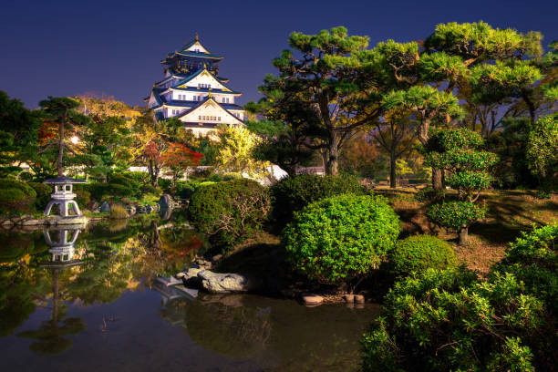 view on illuminated Osaka Castle from the garden at night, Osaka, Japan