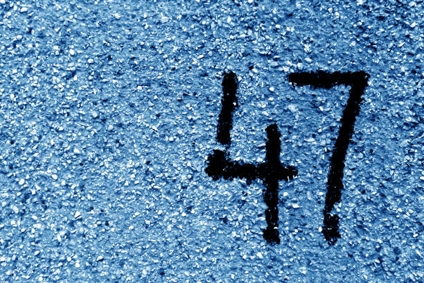 istock Number 47 on cement wall in stencil in navy blue tone. 1145199736