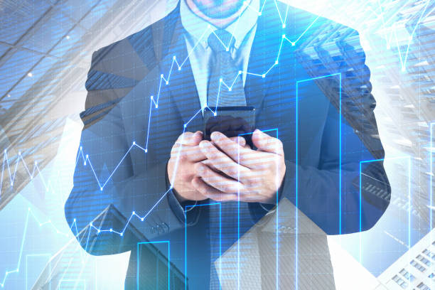 istock Businessman with smartphone, graph and buildings 1145205954