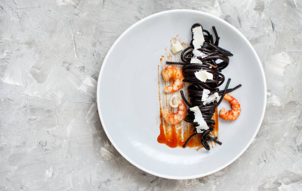 istock Squid ink pasta with prawns and tomatoes 1145206425