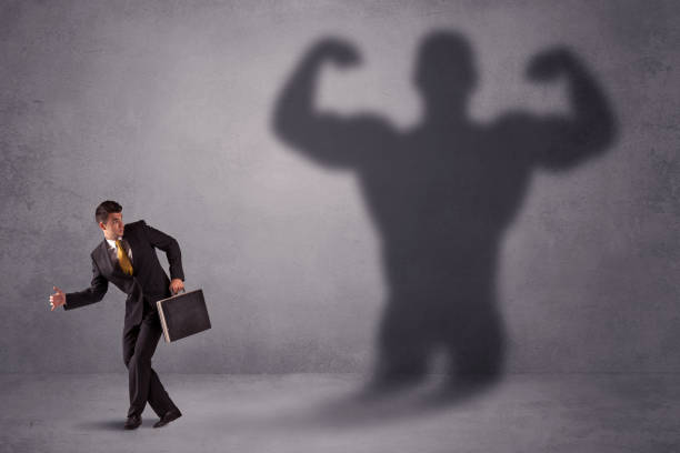 istock Business man looking at his own strong fit shadow concept 1145209885