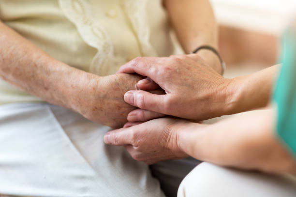 istock Nurse consoling her elderly patient by holding her hands 1145212163