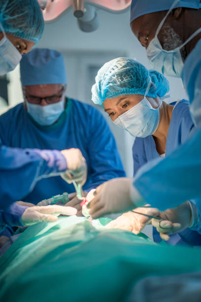 healthcare workers performing surgery on patient - surgeon urgency expertise emergency services imagens e fotografias de stock